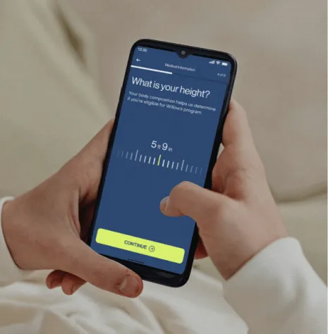 Manos sosteniendo un teléfono con la pantalla de la evaluación médica en línea.